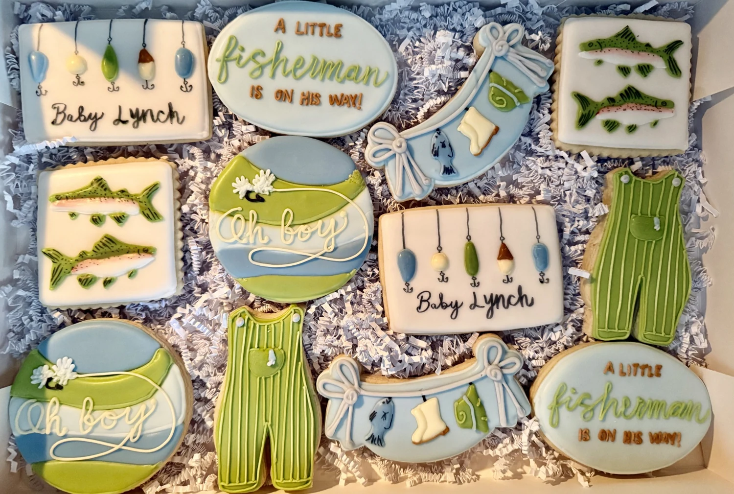 Fishing-themed baby shower cookie collection with rods and fish