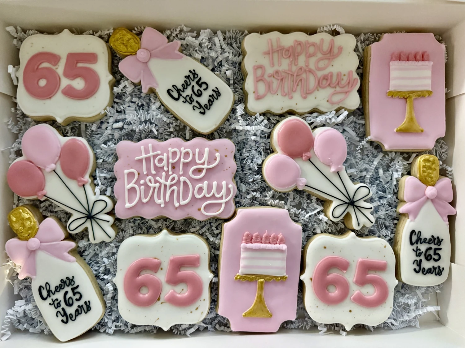 Pink birthday cookie collection with cakes, flowers, and celebratory lettering